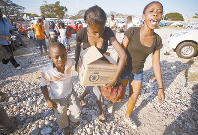 1月17日,几名海地人在太子港领取援助物资后离开